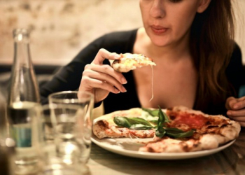 Perempuan sedang menikmati makan malam di restoran/paxel.com