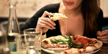 Perempuan sedang menikmati makan malam di restoran/paxel.com