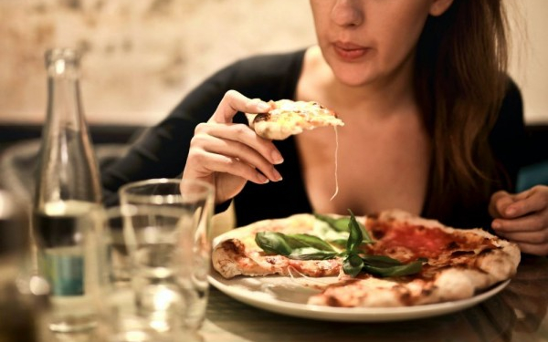 Perempuan sedang menikmati makan malam di restoran/paxel.com