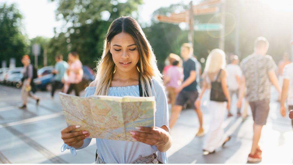 Seorang perempuan sedang memegang map di suatu tempat foto by canva